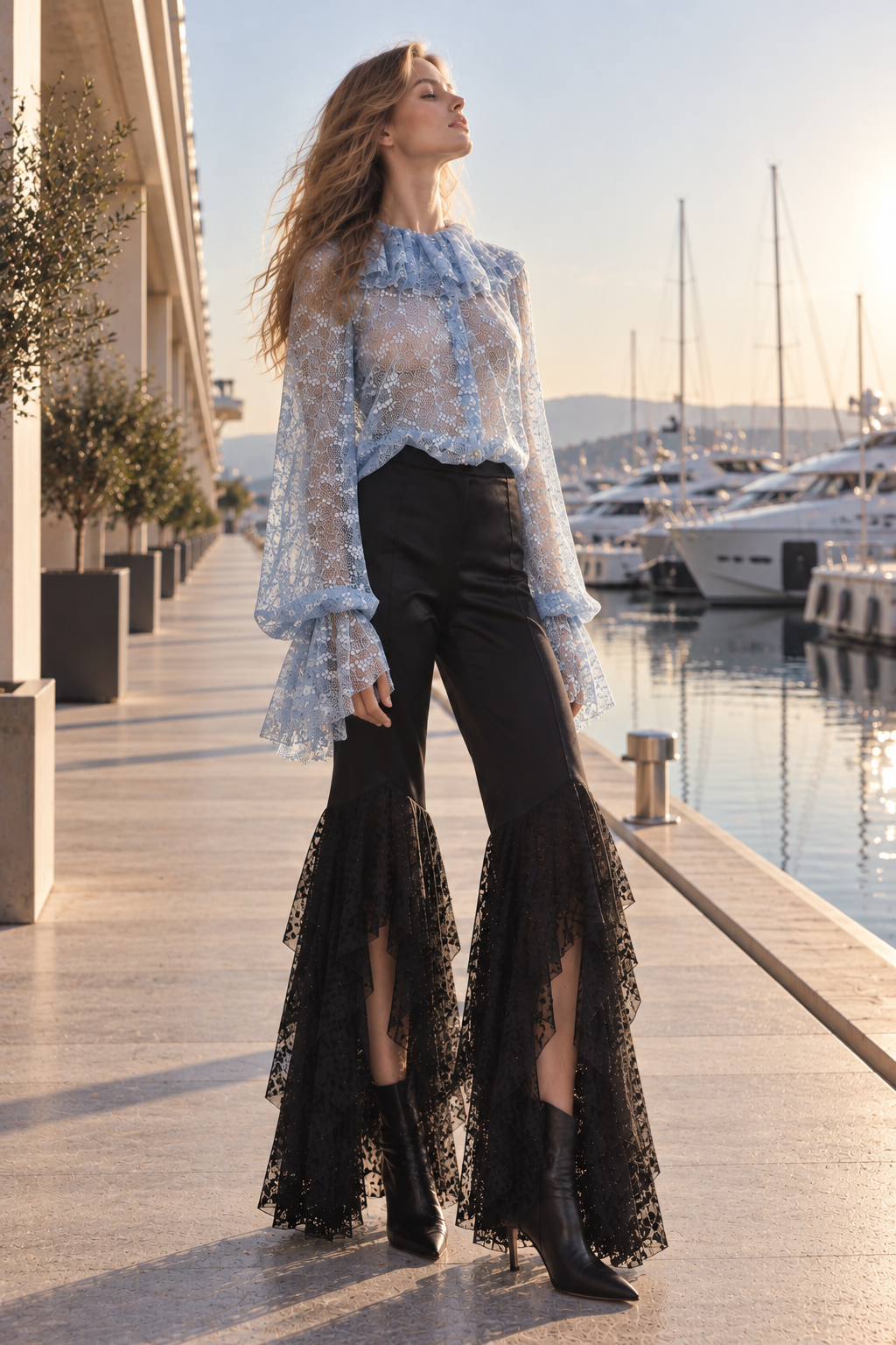 Blouse en dentelle bleue à volants portée avec un pantalon noir aux bas de jambes en dentelle de la Collection Prêt-à-Porter 2026 LYSANDRE PARIS.