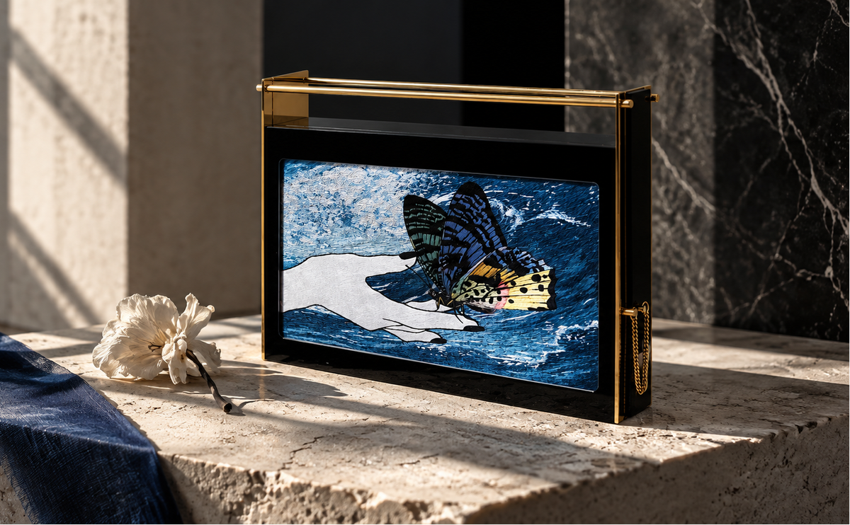 Fantasy Clutch 106 « A Tender Touch » de LYSANDRE PARIS, minaudière artisanale ornée d’une broderie de soie représentant des papillons délicatement posés sur une main.