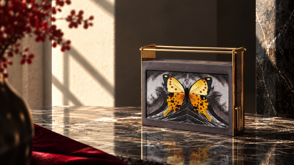 Minaudière brodée « Par-delà les Océans » de LYSANDRE PARIS, broderie représentant un papillon jaune et orangé, évocation du voyage et de la liberté.